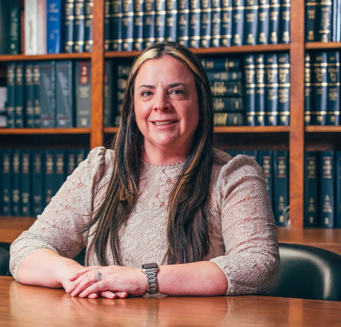 Carly D. Roberts seated at a desk in the firm's law library.