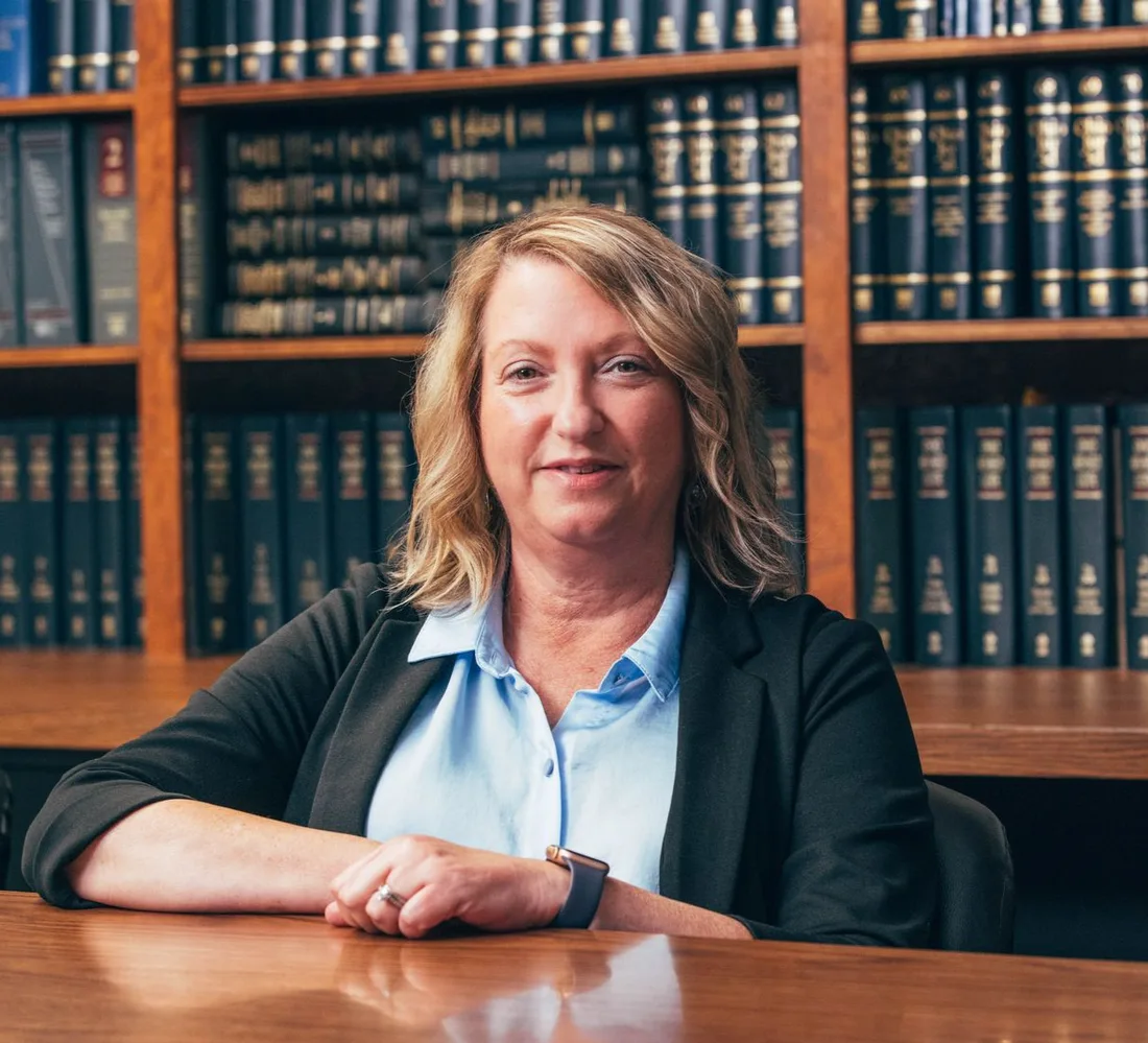 Lori Palermo, probate and estate planning paralegal, seated in the firm's law library.